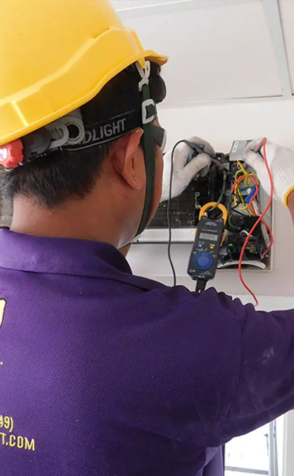 We will fix it employee servicing air conditioner with temperature gun meter