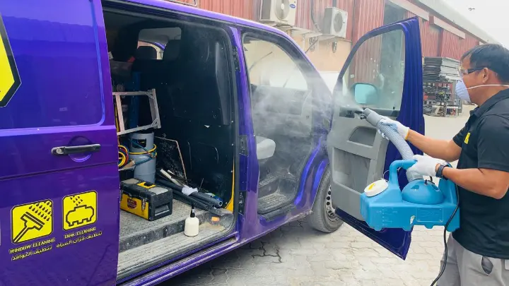 Man cleaning We Will Fix It van with high pressure washer