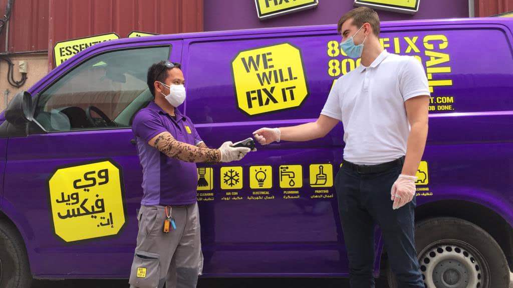 Man using card payment to employee in front of We Will Fix It van