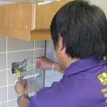 We will fix it employee fixing electrical wiring on wall