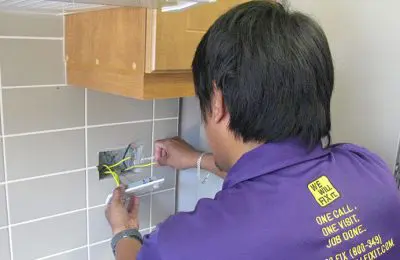 We will fix it employee fixing electrical wiring on wall