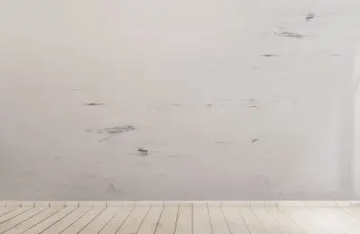 Hardwood white floor with a dirty wall