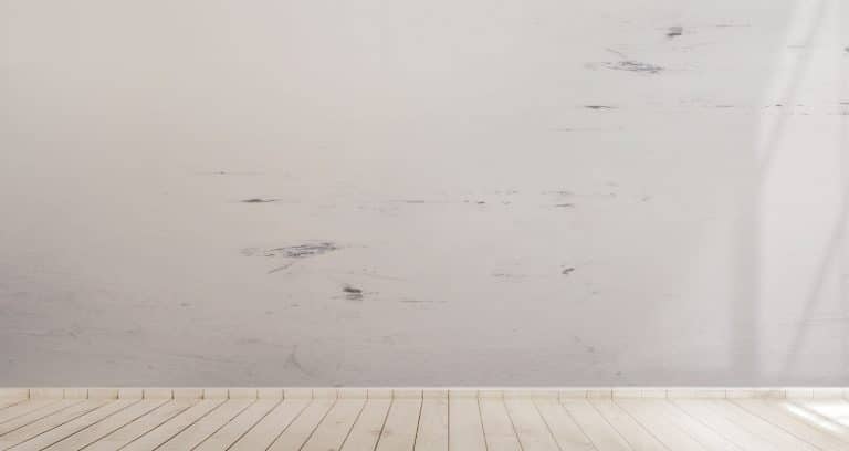 Hardwood white floor with a dirty wall