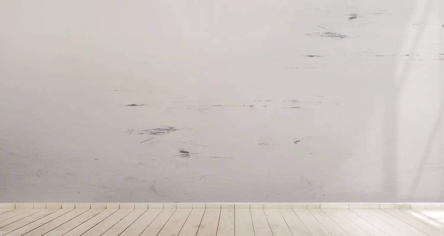 Hardwood white floor with a dirty wall