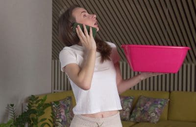 A woman on the phone looking up holding a bucket