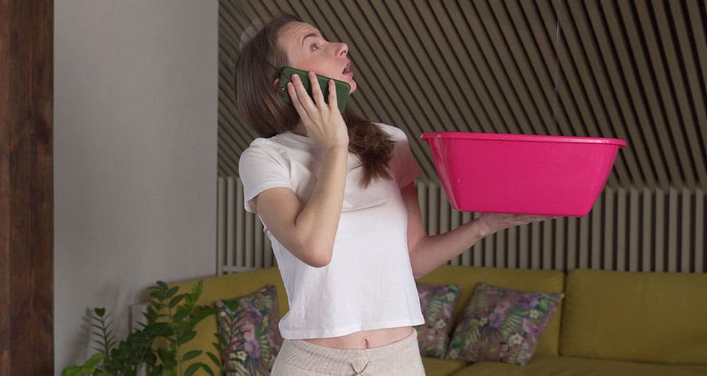 A woman on the phone looking up holding a bucket