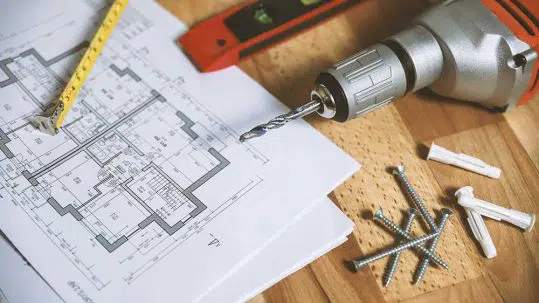 House blueprint with tools and drill machine