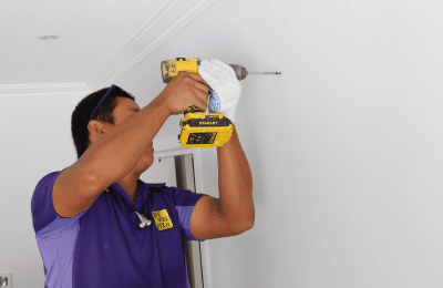 We will fix it employee drilling on dry wall with drill machine