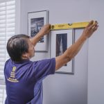 Handyman hanging frames on the wall