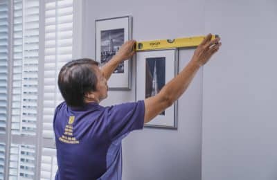 Handyman hanging frames on the wall