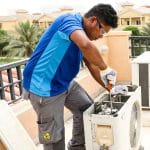 AC technician servicing the air conditioning unit